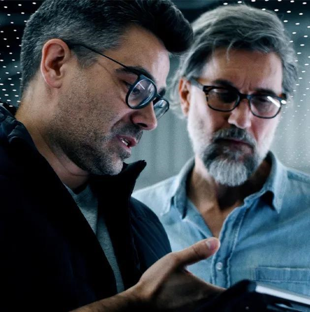 Deux hommes discutant tout en regardant une tablette